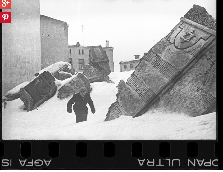 Photo: un homme marche dans la neige au milieu des ruines de la synagogue de Via Wolborska, détruite par les Allemands en 1939.