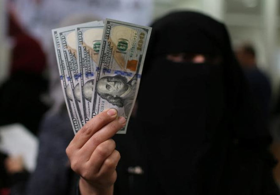 Une fonctionnaire palestinienne recrutée par le Hamas montre des billets en dollars américains après avoir reçu son salaire payé par le Qatar, à Khan Younis, dans le sud de la bande de Gaza, le 7 décembre 2018... (crédit photo : IBRAHEEM ABU MUSTAFA/REUTERS)