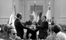 Le président égyptien Anouar el-Sadate, le président américain Jimmy Carter et le Premier ministre israélien Menahem Begin (de gauche à droite) se donnent une poignée de main groupée après avoir signé le traité de paix entre l’Égypte et Israël en 1979.