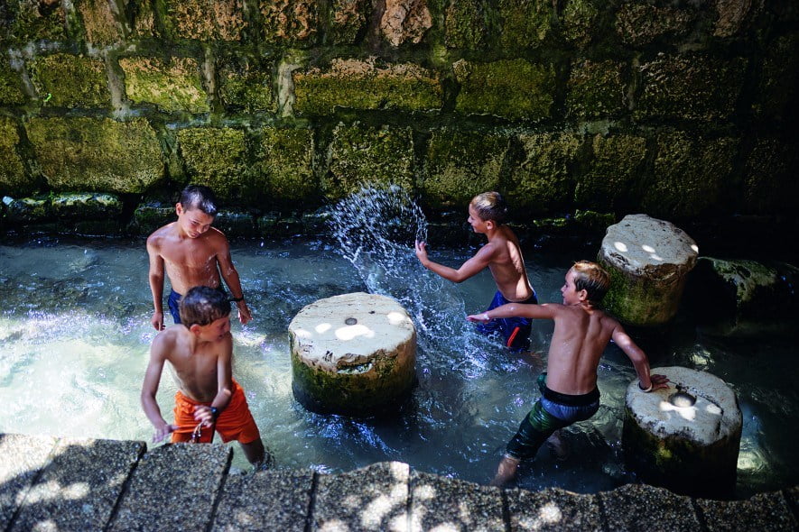 Des enfants jouent au débouché du tunnel d’Ézéchias, qui apporte l’eau jusqu’à ce bassin depuis la source du Gihon (à 533 m de là), la principale source de la Jérusalem antique. Ézéchias aurait fait creuser le tunnel pour sécuriser les ressources en eau de la ville.