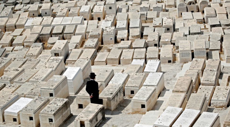 Un homme se recueille sur une tombe dans le cimetière juif du Mont des Oliviers, en face de la Vieille ville de Jérusalem, le 9 septembre 2018 Photo THOMAS COEX. AFP