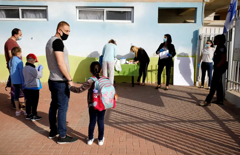 PHOTO DE DOSSIER: Les parents attendent avec leurs enfants pour entrer dans leur école primaire de Sderot qui rouvrira à la suite de la facilité des restrictions empêchant la propagation de la maladie à coronavirus (COVID-19) en Israël 3 mai 2020 (crédit photo: REUTERS / AMIR COHEN / FILE PHOTO)