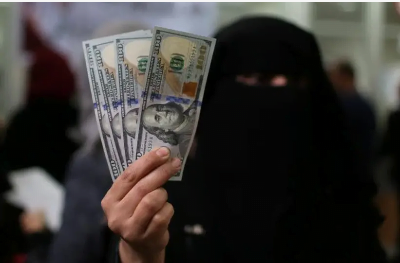 Un fonctionnaire palestinien embauché par le Hamas affiche des billets en dollars américains après avoir reçu son salaire payé par le Qatar, à Khan Younis, dans le sud de la bande de Gaza, le 7 décembre 2018. (crédit photo: IBRAHEEM ABU MUSTAFA / REUTERS)