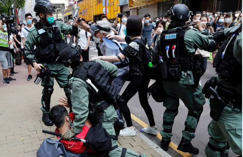 Des manifestants anti-gouvernementaux se disputent avec la police anti-émeute lors d'une manifestation à l'heure du déjeuner alors qu'une deuxième lecture d'une loi controversée sur l'hymne national a lieu à Hong Kong, Chine, le 27