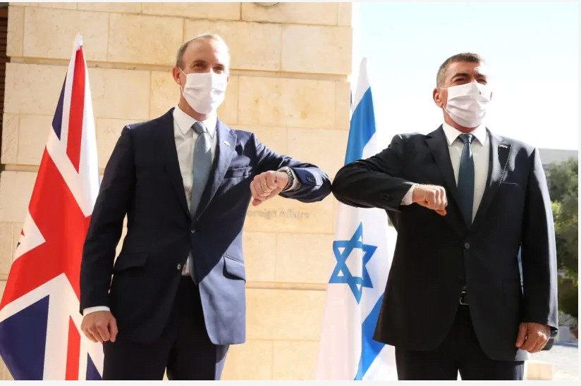 Le ministre britannique des Affaires étrangères Dominic Raab rencontre le ministre israélien des Affaires étrangères Gabi Ashkenazi à son arrivée en Israël, le 25 août 2020 (crédit photo: MIRI SHIMONOVICH / GPO)