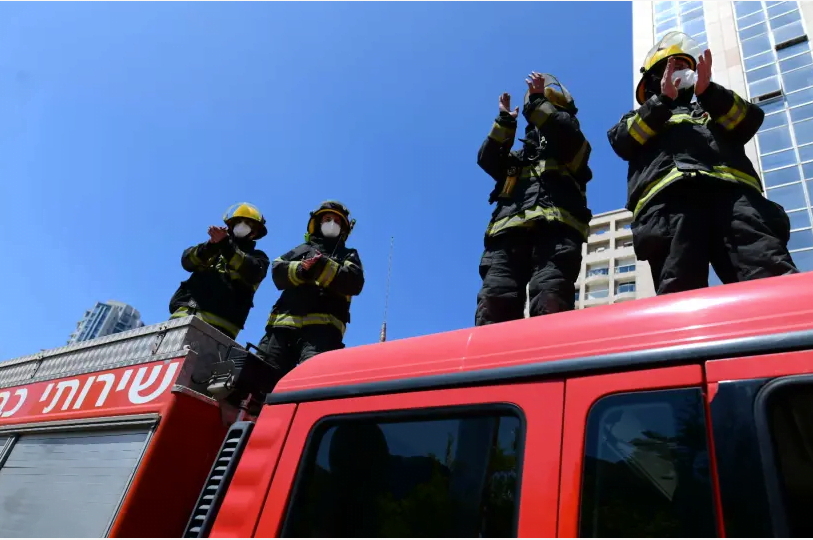 Les pompiers israéliens applaudissent le personnel médical luttant contre le coronavirus devant l'hôpital Ichilov de Tel Aviv le 7 avril 2020. (crédit photo: TOMER NEUBERG / FLASH90) Publicité
