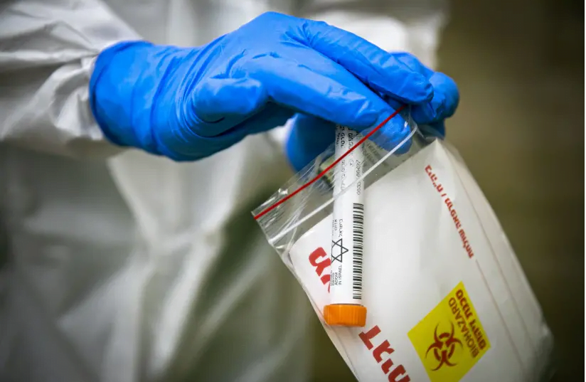 Des membres de l'équipe médicale du Magen David Adom, portant un équipement de protection, effectuent un test de coronavirus sur des patients à Jérusalem, le 17 avril 2020. (crédit photo: OLIVIER FITOUSSI / FLASH90)