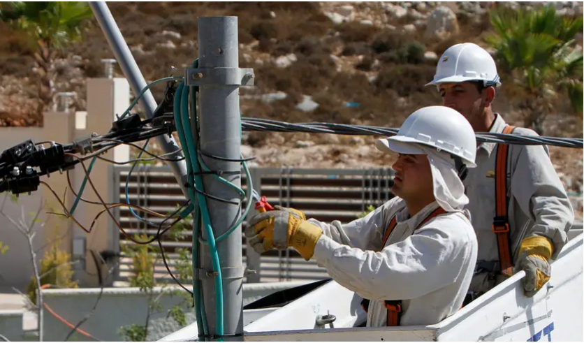 Des électriciens installent de nouvelles lignes de transport d'électricité sur un chantier de construction dans la ville cisjordanienne de Ramallah, le 3 septembre 2012. Crédit: REUTERS