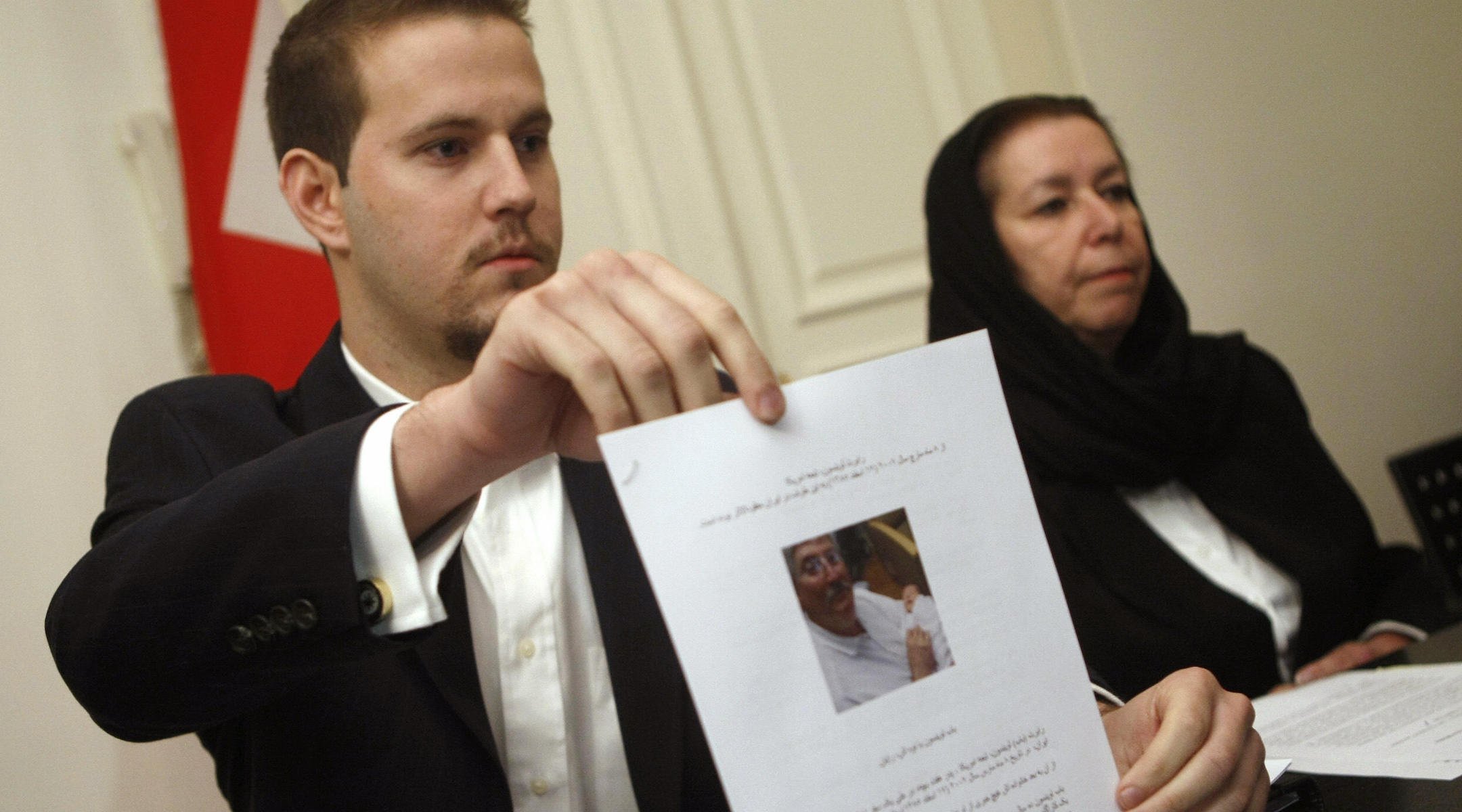 Daniel Levinson montre une photo de son père, l'ancien agent du FBI Robert Levinson, tenant son petit-fils Ryan lors d'une conférence de presse avec sa mère Christine à l'ambassade de Suisse à Téhéran, le 22 décembre 2007. (Behrouz Mehri / AFP via Getty Images)