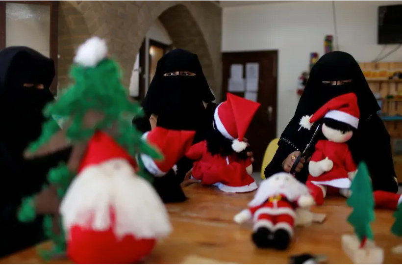 Des Palestiniennes portant un voile facial et du niqab fabriquent des jouets de Noël sur le thème du Père Noël dans le nord de la bande de Gaza (crédit photo: REUTERS)