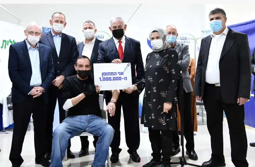 Le Premier ministre Benjamin Netanyahu, accompagné du ministre de la Santé Yuli Edelstein, rend visite à la millionième personne à recevoir le vaccin contre le coronavirus, Umm el-Fahm, 1er janvier 2021 (crédit photo: HAIM ZACH / GPO)