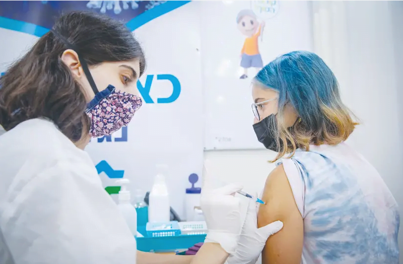 DES JEUNES REÇOIVENT leur vaccin COVID-19 dans un centre Clalit à Jérusalem en août. (crédit photo : OLIVIER FITOUSSI/FLASH90)