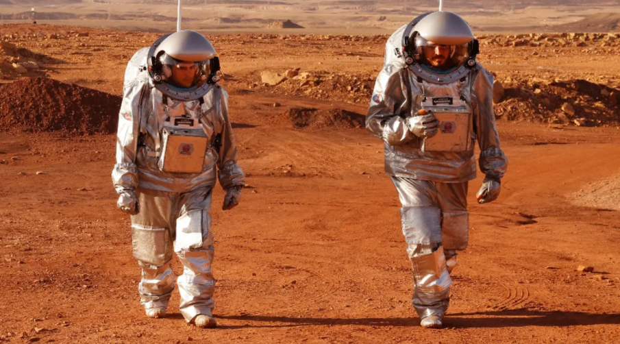 Deux astronautes d'une équipe israélo-européenne avant de commencer une mission d'entraînement pour la planète Mars sur un site qui simule une station hors site au cratère Ramon à Mitzpe Ramon dans le désert du sud du Néguev, en Israël, le 10 octobre 2021 AFP / JACK GUEZ.
